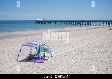 Adélaïde, Australie, 11 février 2025. Les amateurs de plage s'abritant sous le gazebo de la plage du soleil chaud dans la banlieue de Henley. Un avertissement de vague de chaleur « code rouge » a été émis pour les parties de l'Afrique du Sud dont les températures devraient atteindre 40 °c. Crédit. Amer Ghazzal/Alamy Live News Banque D'Images