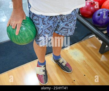 Personne tenant une boule de bowling dans l'allée prête à jouer. Banque D'Images