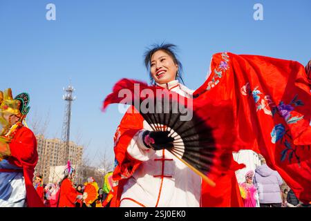 Comté de Luannan, Chine - 12 février 2025 : les gens vêtus de beaux costumes dansent le yangko pour célébrer le nouvel an chinois traditionnel. Banque D'Images