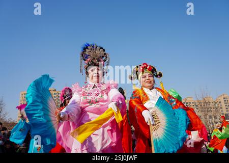 Comté de Luannan, Chine - 12 février 2025 : les gens vêtus de beaux costumes dansent le yangko pour célébrer le nouvel an chinois traditionnel. Banque D'Images