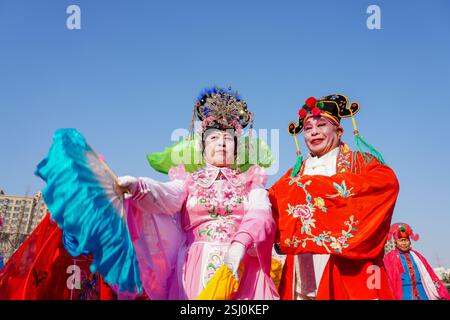 Comté de Luannan, Chine - 12 février 2025 : les gens vêtus de beaux costumes dansent le yangko pour célébrer le nouvel an chinois traditionnel. Banque D'Images