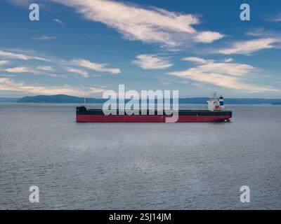 Vue aérienne d'un grand cargo dans une baie calme sous un ciel nuageux Banque D'Images