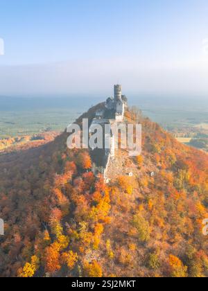 Le château médiéval de Bezdez se dresse majestueusement au sommet d'une colline, entouré d'un feuillage d'automne vibrant. Le paysage coloré met en valeur la beauté de l'automne dans cet endroit historique. Banque D'Images