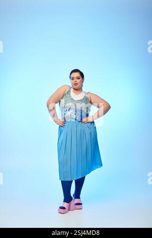 Jeune femme de taille plus présente une superbe tenue bleue, rayonnant de confiance et de beauté. Banque D'Images