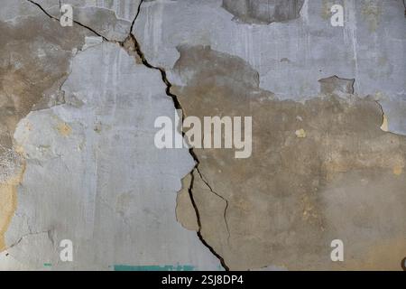 Intérieur d'une vieille maison délabrée le mur fissuré a des traces de vieux plâtre et de moisissure de peinture peut être vu grandir sur le mur extérieur humide Photogr Banque D'Images