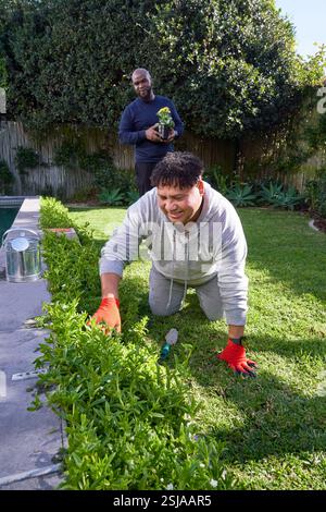 Homme plantant des fleurs dans le jardin Banque D'Images