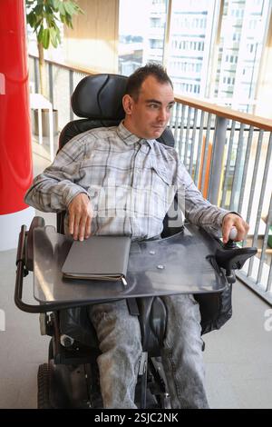 Homme en fauteuil roulant dans un environnement de bureau Banque D'Images
