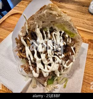 Un délicieux et savoureux shawarma de poulet enveloppé généreusement de légumes frais et arrosé de sauce crémeuse Banque D'Images