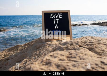 Donnez-lui un symbole essayer. Les mots conceptuels lui donnent un essai sur le tableau noir de craie. Beau fond de mer. Et donnez-lui un concept d'essai. Copier l'espace. Banque D'Images