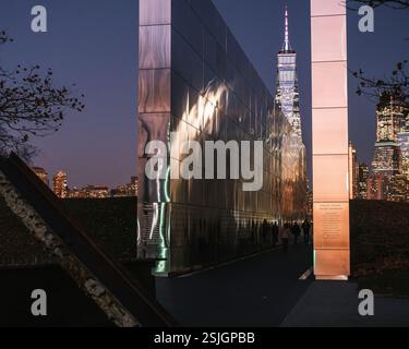 Le Empty Sky Memorial à Liberty State Park, New Jersey, illuminé la nuit avec des reflets de l'horizon de Manhattan. Dédié en 2011. Banque D'Images