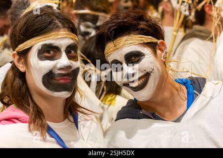 Un jeune couple au visage peint en noir et blanc sourit pendant la procession nocturne de la flamme, dans le cadre des célébrations du carnaval à Chora, sur l'île de Naxos Banque D'Images