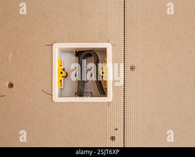 Fixez d'abord la plaque à douille unique électrique dans les plaques de plâtre avec du ruban de jointoiement pour plaques de plâtre Banque D'Images