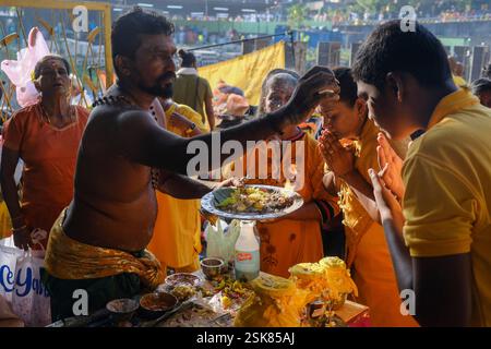 Kuala Lumpur, Malaisie. 11 février 2025. Une famille de dévots hindous vue obtenir une bénédiction d'un swamis pendant le festival Thaipusam au temple Batu Caves à Kuala Lumpur. Crédit : SOPA images Limited/Alamy Live News Banque D'Images