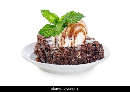 Brownie au chocolat décadent servi avec glace à la vanille et garniture à la menthe sur une assiette blanche Banque D'Images