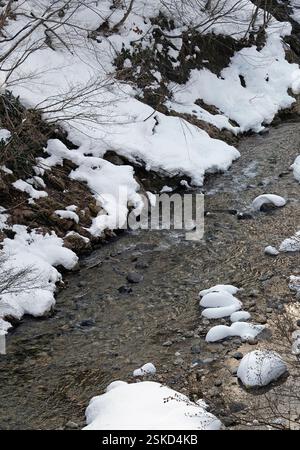 Traversée de rivière à travers un paysage enneigé dans les montagnes au Japon Banque D'Images