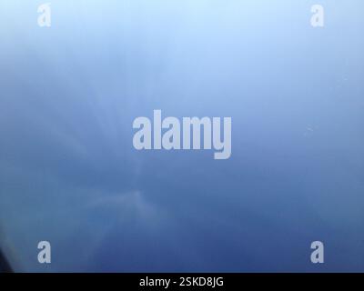 Photo aérienne des Bahamas. Ciel bleu brumeux avec de faibles traînées verticales. Les formations nuageuses projettent des ombres sur l'océan, peut-être des traînées ou un ph météorologique Banque D'Images