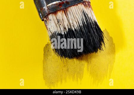 Vieux pinceau de couleur noire sur fond jaune avec trait noir, temps de loisirs ou lieu de travail Banque D'Images