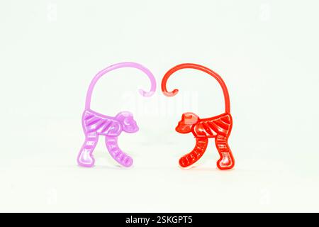Il y a deux jouets de singe, rouge et violet. Ces jouets sont disponibles gratuitement avec des collations comme des chips pour les enfants. Le jouet est en plastique, enfants Banque D'Images