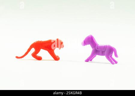 Il y a un tigre et un jouet cheval. Les jouets sont en plastique, avec lequel les enfants jouent. cette couleur de jouets est rouge et violet Banque D'Images