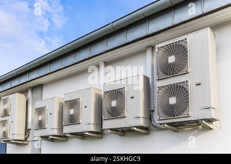 Rangée de doubles variateurs, combinaison de pompe de chauffage et de refroidissement, installés sur un bâtiment industriel Banque D'Images