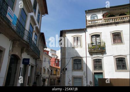 De charmants bâtiments anciens avec balcons bordent une rue pavée étroite, Braga, Portugal. Un aperçu de l'histoire d'une ville dynamique. Potentiel réel Banque D'Images