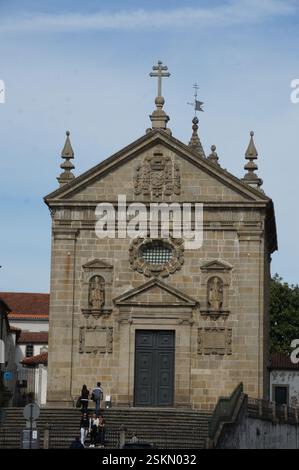 Façade d'église en pierre à Braga, Portugal. Des sculptures complexes, des statues et une croix centrale ornent la pierre altérée. Un témoignage de siècles de foi Banque D'Images