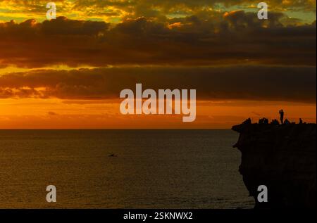 Silhouette d'un homme debout parmi un groupe de personnes regardant le coucher du soleil et prenant des photos, plage de Los Molinos, Fuerteventura, îles Canaries, Espagne Banque D'Images