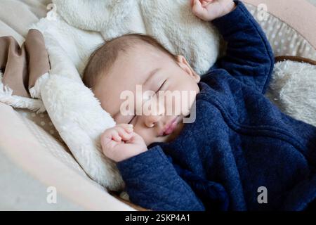 Gros plan d'un garçon nouveau-né endormi dans un videur de bébé Banque D'Images