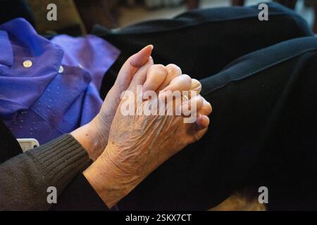 Les mains des femmes âgées se sont serrées, révélant des rides et une alliance Banque D'Images