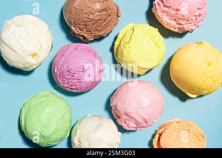 Cuillères assorties de crème glacée sur fond bleu, vue de dessus, motif créatif. Diverses crèmes glacées ou gelato, concept de dessert d'été sain. Banque D'Images