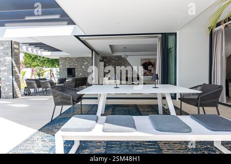 une image rapprochée d'une table à manger extérieure avec des bancs dans la luxueuse maison de vacances méditerranéenne Banque D'Images