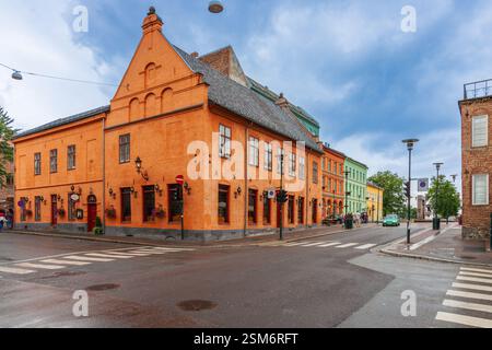 Des bâtiments colorés bordent les rues près du restaurant Gamle Raadhus, mettant en valeur l'architecture d'Oslo sous un ciel nuageux. Banque D'Images