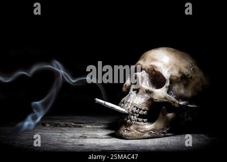 Nature morte avec le crâne humain et les gens de cigarette fument concept de cigarette Banque D'Images
