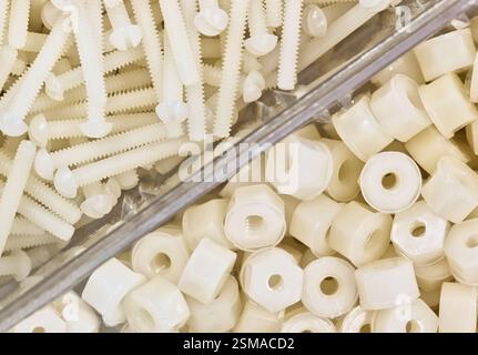 Écrous et boulons en nylon en plastique blanc boulonnerie de vis mécaniques accessoires divisés d'outils de travail. Banque D'Images