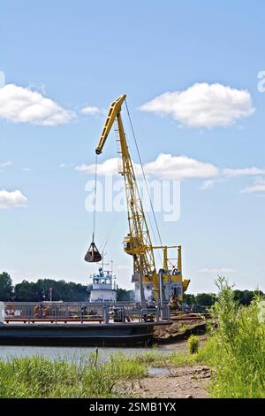 Chargement de sable à l'aide d'une grue jaune sur une barge. River White, Russie, Europe Banque D'Images