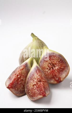 Fruit, Figs Ficus Carica Anjir un plein et un autre coupé en trois morceaux rouge texture juteuse sur fond blanc Banque D'Images