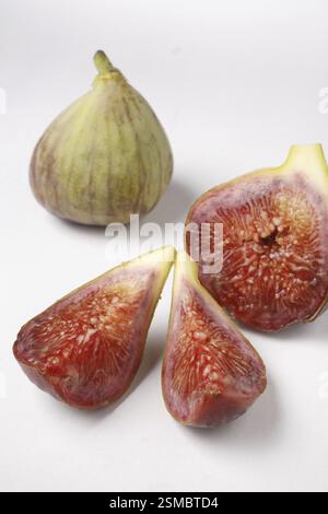 Des fruits, une Fig Ficus carica Anjir et un autre coupé en trois morceaux sur fond blanc Banque D'Images