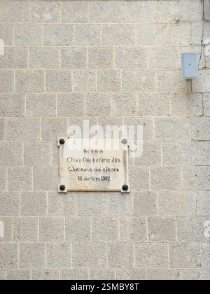 Kotor, Monténégro - 2 juillet 2024 : ancien centre historique. Plaque de l'église Saint-Nicolas commémorant le début de sa construction en 1902 Banque D'Images