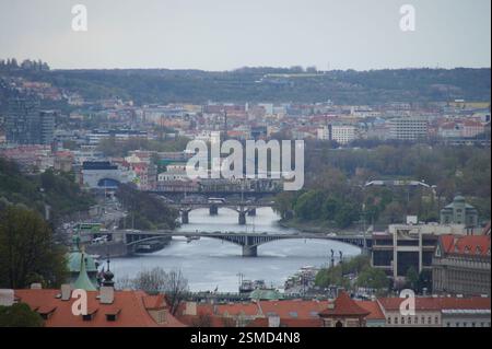 Panorama de Prague. Des toits rouges bordent la rive de la Vltava, avec des ponts qui s'étendent sur l'eau. L'architecture de la ville mêle baroque et gothique s. Banque D'Images