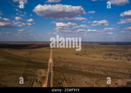 Région de Marra Creek à Tilpa, Nouvelle-Galles du Sud, Australie. La scène est dominée par une longue route droite. Banque D'Images