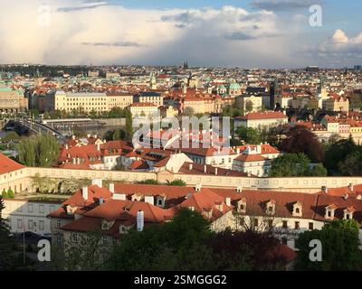 Le château de Prague domine le paysage urbain avec ses toits rouges. Le pont Charles s'étend sur la rivière Vltava. Un symbole de l'histoire et du cultu tchèques Banque D'Images