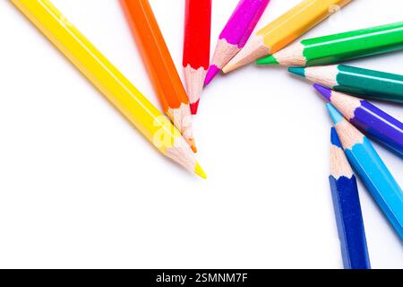 Assortiment coloré de crayons de couleur disposés dans un motif circulaire sur une surface blanche pour des projets artistiques créatifs Banque D'Images