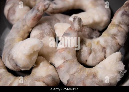 Crevettes tigrées crues congelées crevettes dans un bol gris sur une table de cuisine grise Banque D'Images