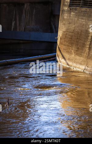 Rånåsfoss où la force de la nature rencontre l'ingéniosité humaine. La lumière dorée révèle la danse des tourbillons et de l’architecture, un équilibre entre puissance et harmoy Banque D'Images
