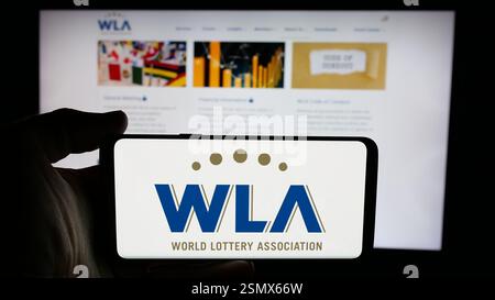 Allemagne. 20 novembre 2024. Dans cette illustration photo, une personne tient un téléphone portable avec le logo de l'organisation World Lottery Association (WLA) sur l'écran en face de la page Web. (Crédit image : © timon Schneider/SOPA images via ZUMA Press Wire) USAGE ÉDITORIAL SEULEMENT ! Non destiné à UN USAGE commercial ! Banque D'Images