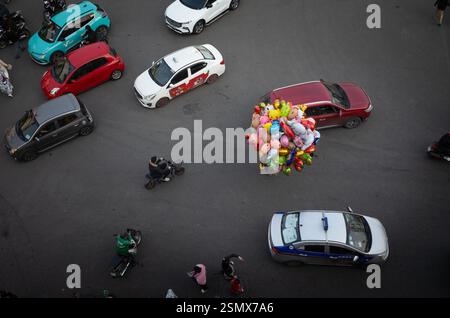 Regardant vers le bas sur les bus touristiques à toit ouvert, les voitures, les motos et les gens à l'extrémité nord du lac Hoan Kiem dans le centre de Hanoi, Vietnam. Banque D'Images