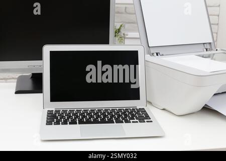 Configuration de l'espace de travail avec un ordinateur portable et une imprimante dans un environnement de bureau moderne Banque D'Images