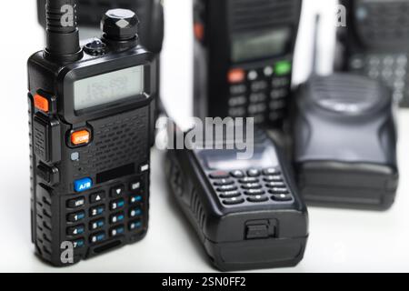 Vue rapprochée de plusieurs radios professionnelles sur une surface blanche et nette présentant divers modèles et fonctionnalités Banque D'Images