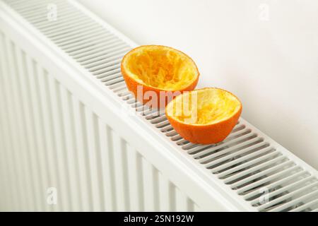 Écorces d'orange sur un radiateur chaud - un désodorisant naturel idéal qui produira une odeur douce agréable qui peut également neutraliser les odeurs désagréables Banque D'Images