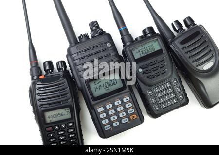 Collection de quatre radios professionnelles portatives disposées sur un fond blanc présentant divers designs et fonctionnalités Banque D'Images